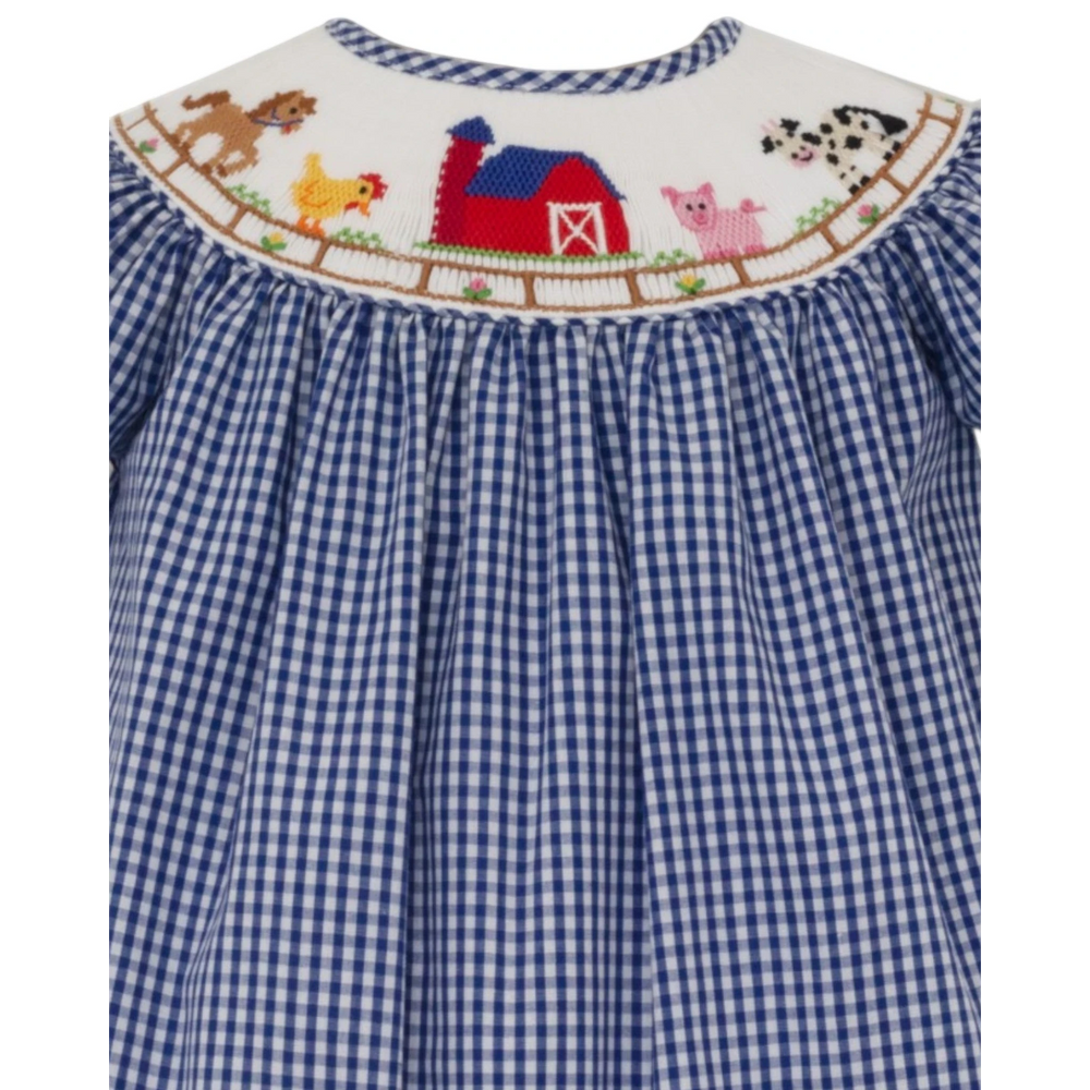 That Store blue gingham bishop dress with detailed farm animal smocking, puff sleeves, and a white collar.