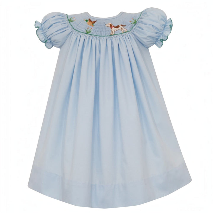 That Store blue smocked bishop dress for girls featuring hand-embroidered hunting dog and mallard duck details.