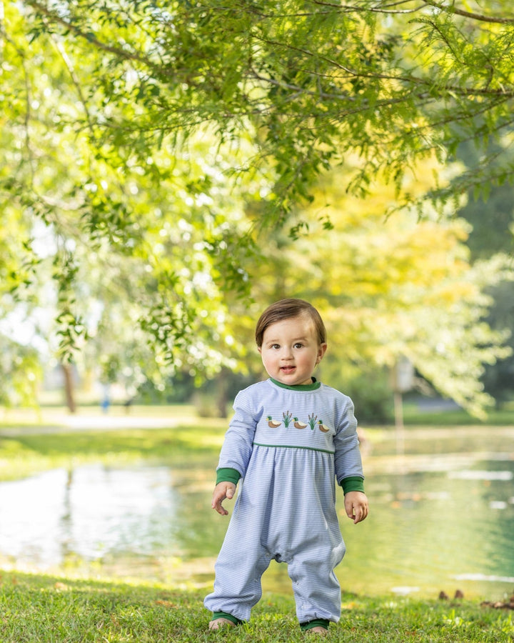That Store blue striped cotton romper with mallard duck embroidery worn by a toddler in a park setting.