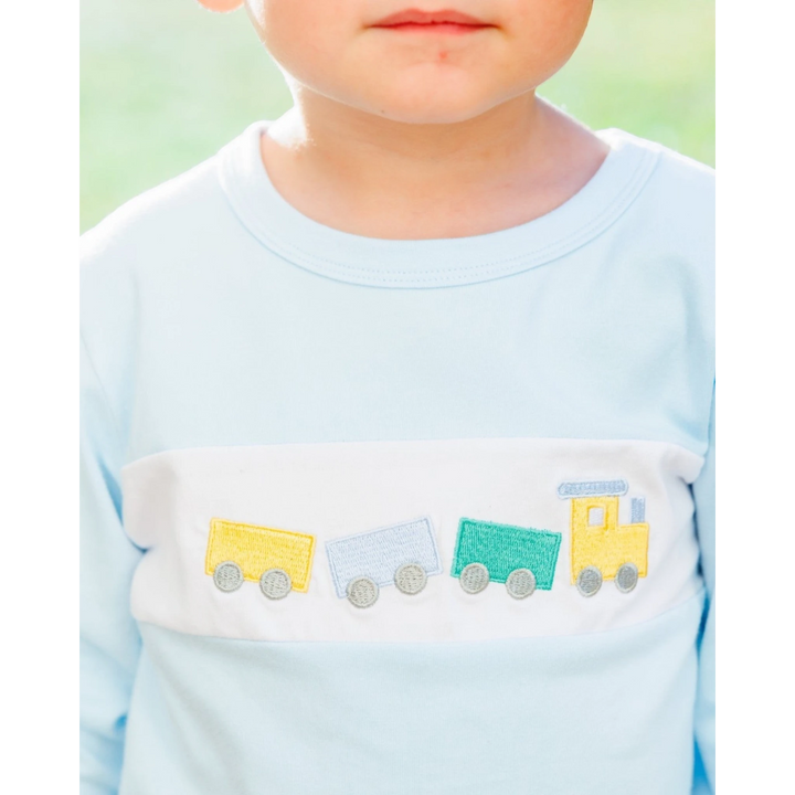 That Store boys light blue long-sleeve shirt with a white chest panel featuring a colorful embroidered train motif.