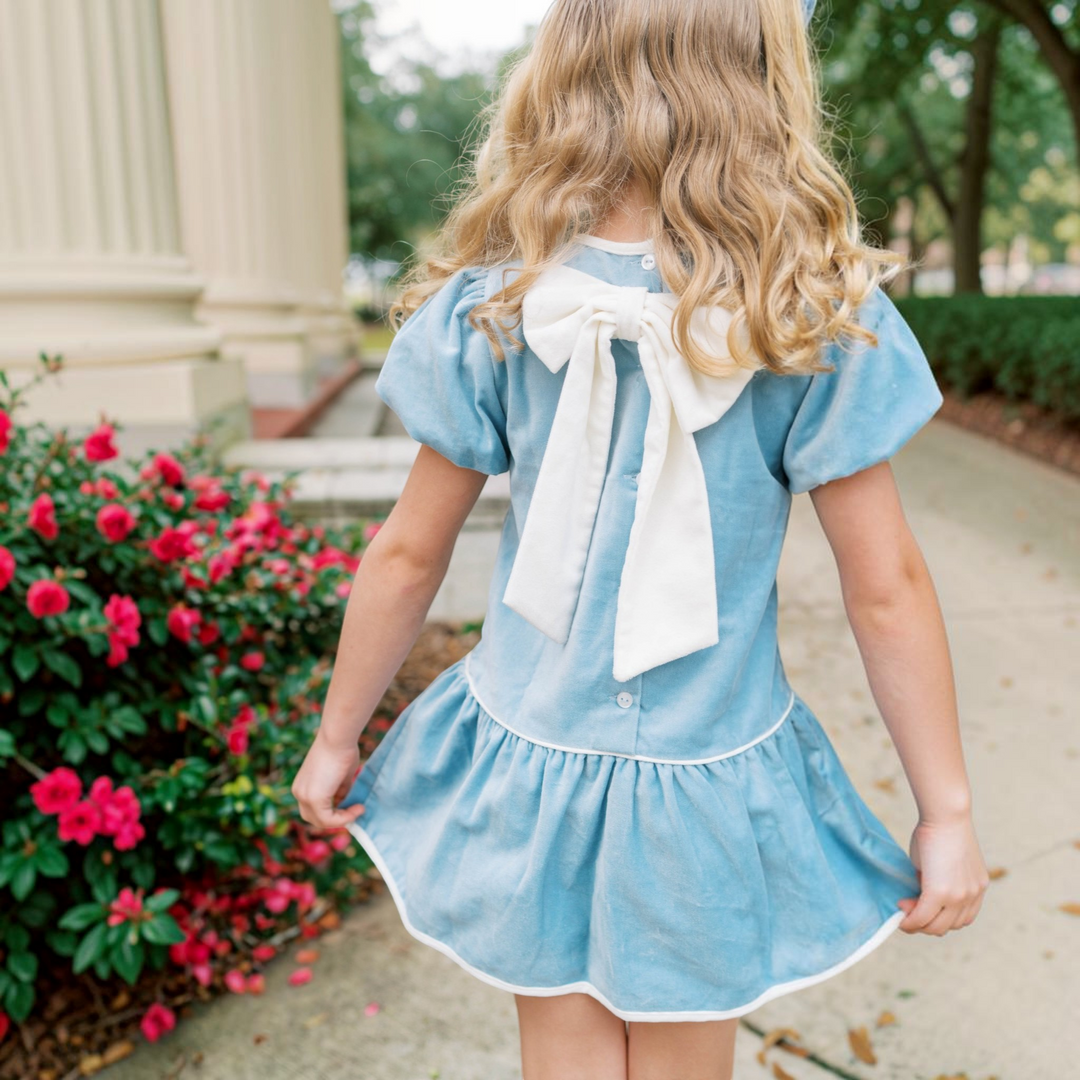 That Store blue velvet dress with winter white bow back detail worn by a young girl for holiday portraits.