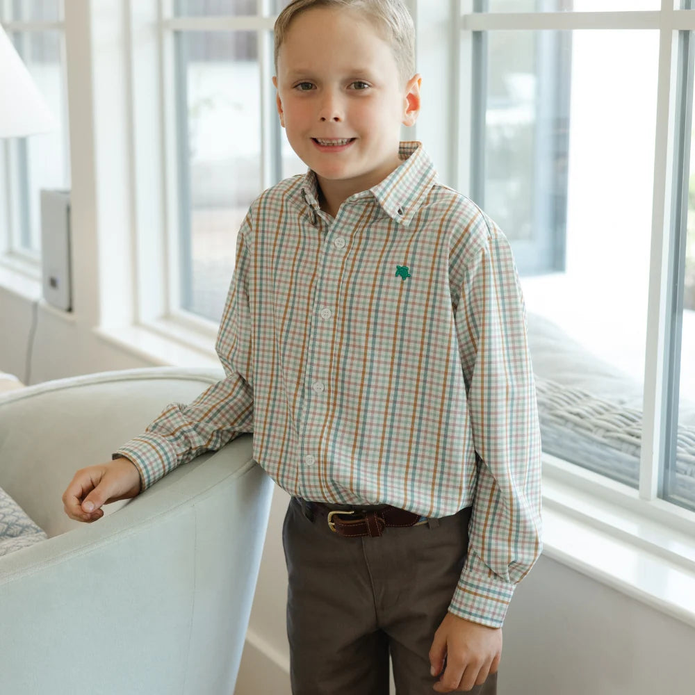A boy wearing a That Store Performance Roscoe button-down shirt in an acorn plaid pattern with long sleeves.