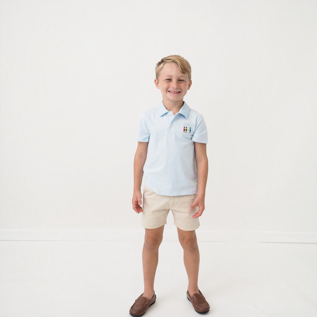 That Store boys blue striped polo shirt with crayon embroidery, worn by a young boy with beige shorts.
