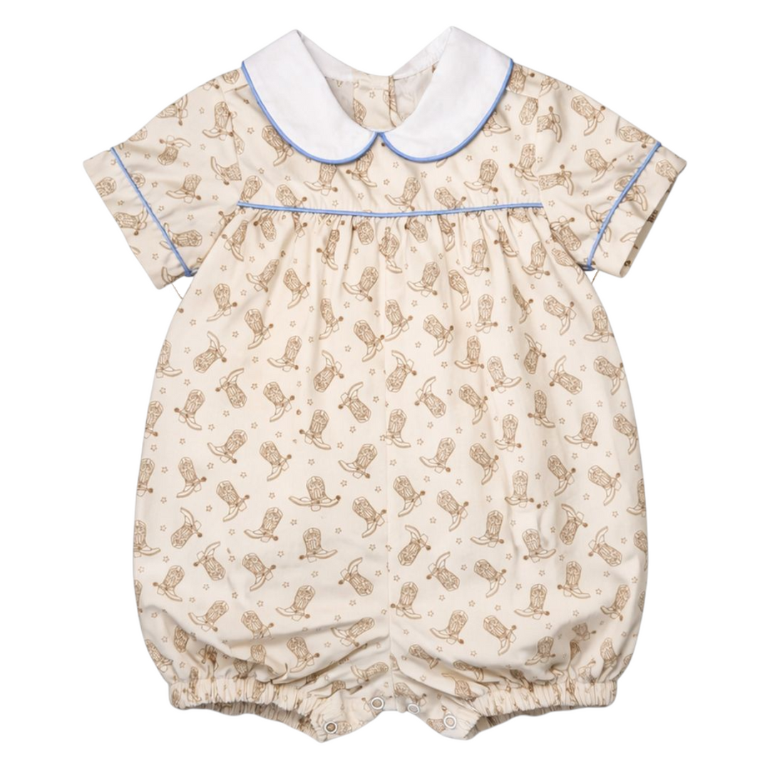 That Store boys bubble romper in beige with brown cowboy boot print, white peter pan collar, and blue piping trim.