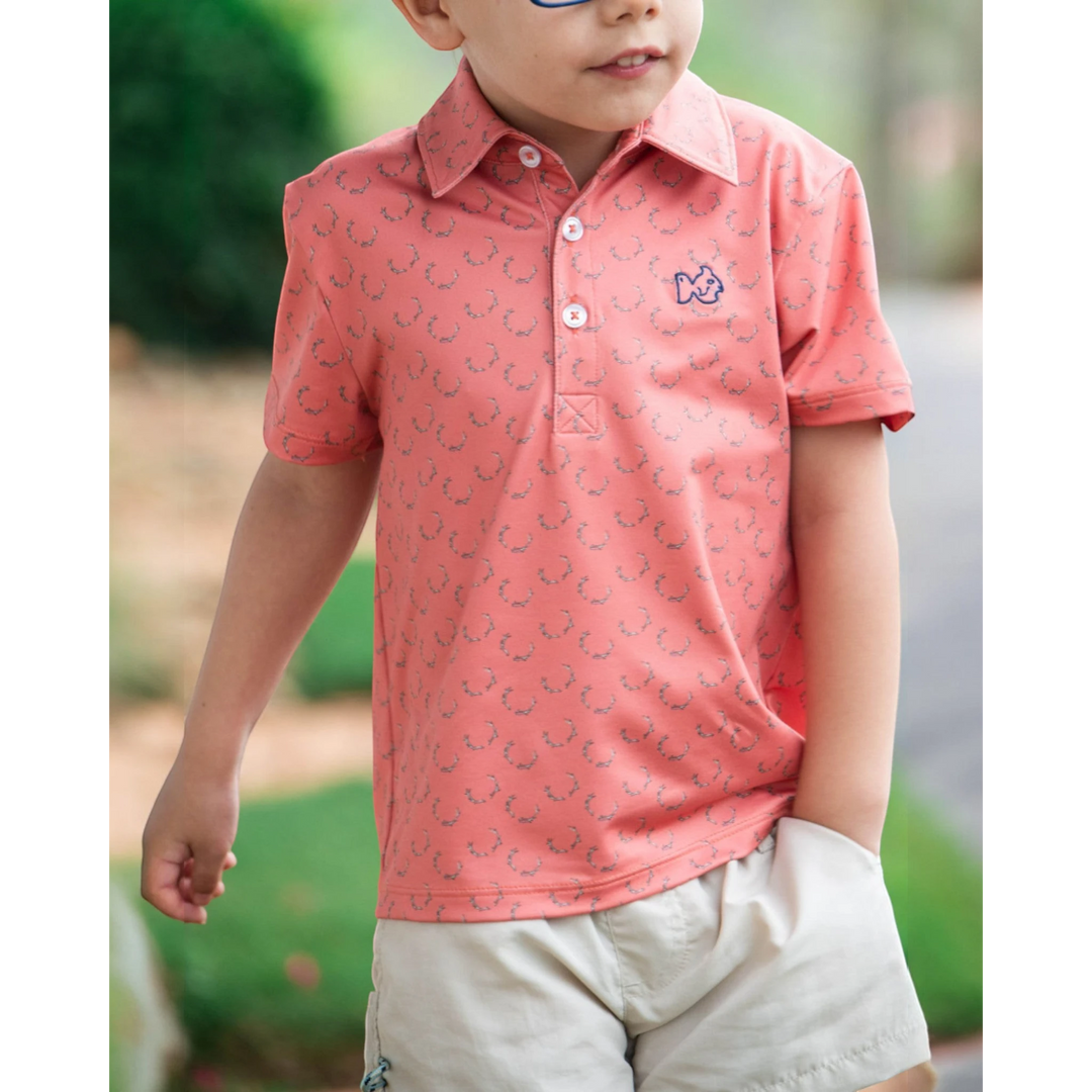 That Store boys performance polo in crabapple with antler print, featuring a 3-button placket and fish logo embroidery.