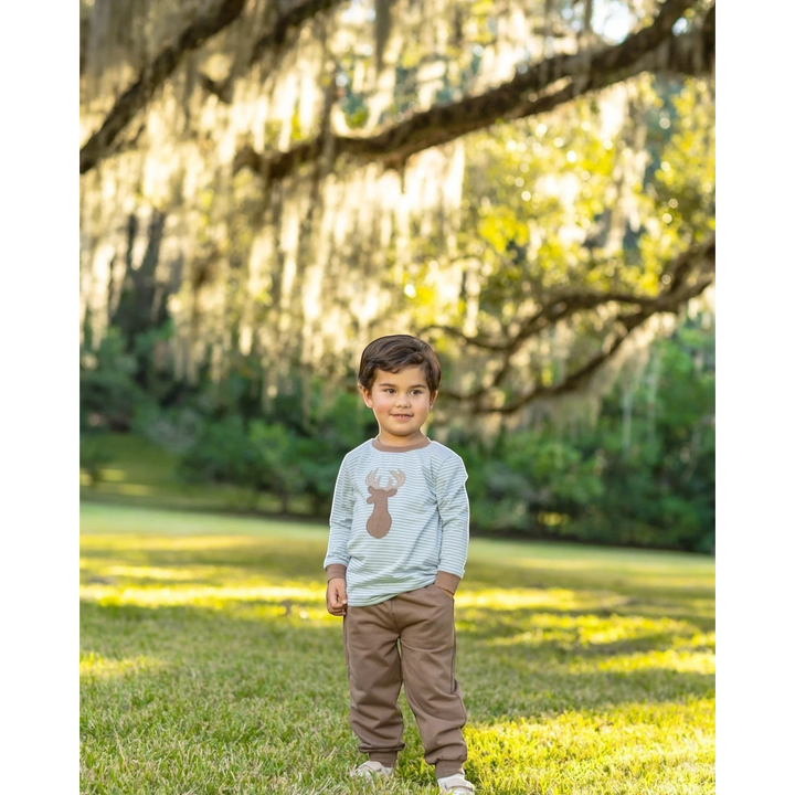 That Store boys jogger set with green striped long sleeve deer applique shirt and brown pants in a park setting