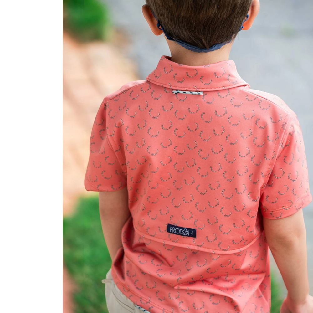 That Store boys performance polo in crabapple with antler print, featuring a vented back and signature loop.