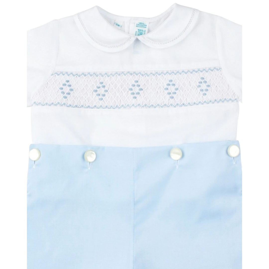 That Store boys bobby suit featuring a white smocked bodice with blue diamond embroidery and light blue pants.