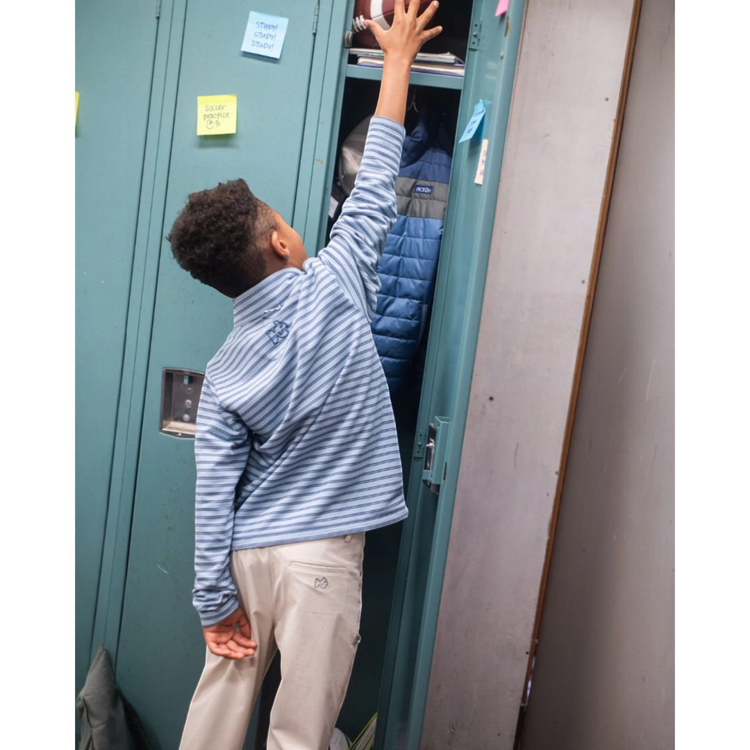 That Store boys sporty snap pullover in ashley blue dark denim stripe with PRODOH logo, worn by a boy at a locker.