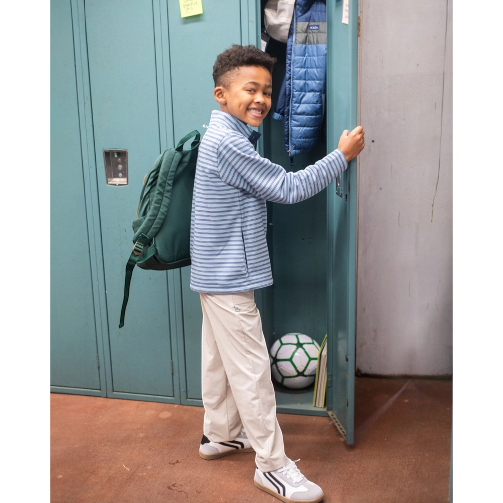 That Store boy wearing a blue striped snap pullover with khaki pants and a green backpack by school lockers