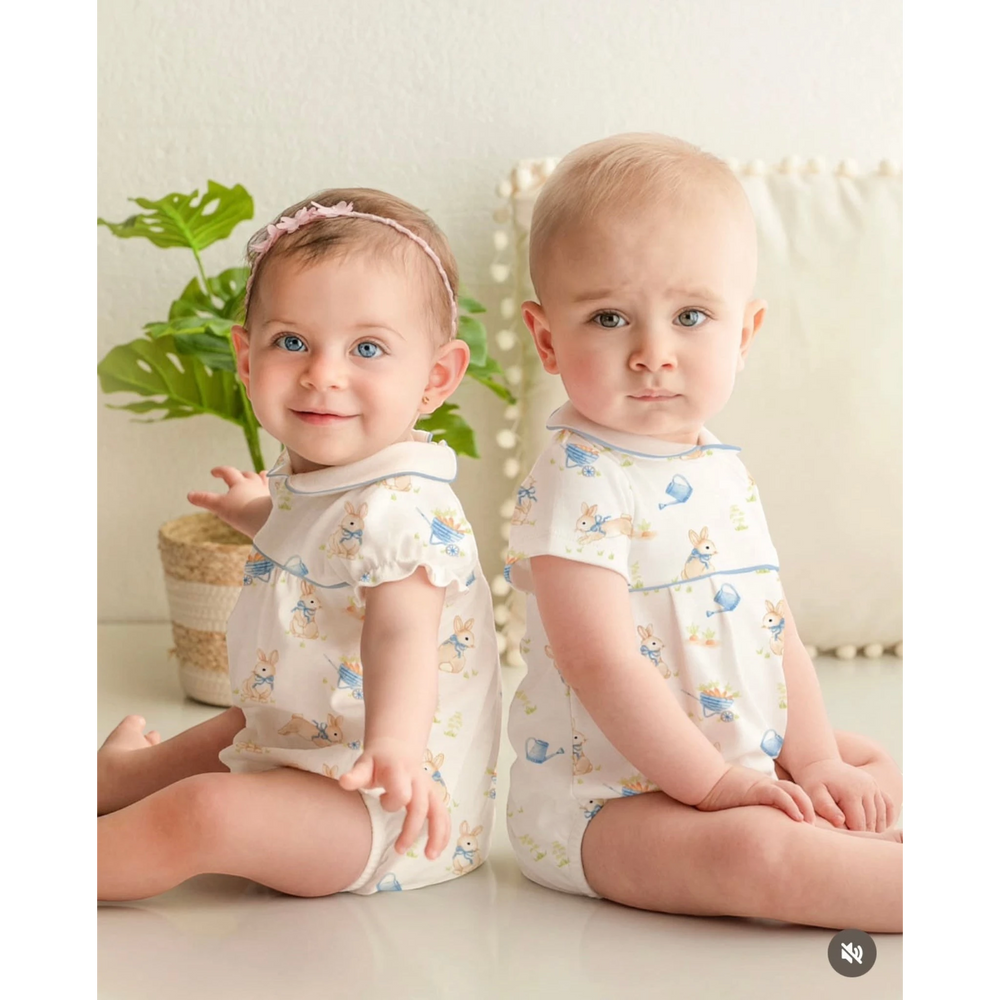Two babies wearing That Store Bunny's Garden Pima cotton bubble rompers with whimsical rabbit and garden print