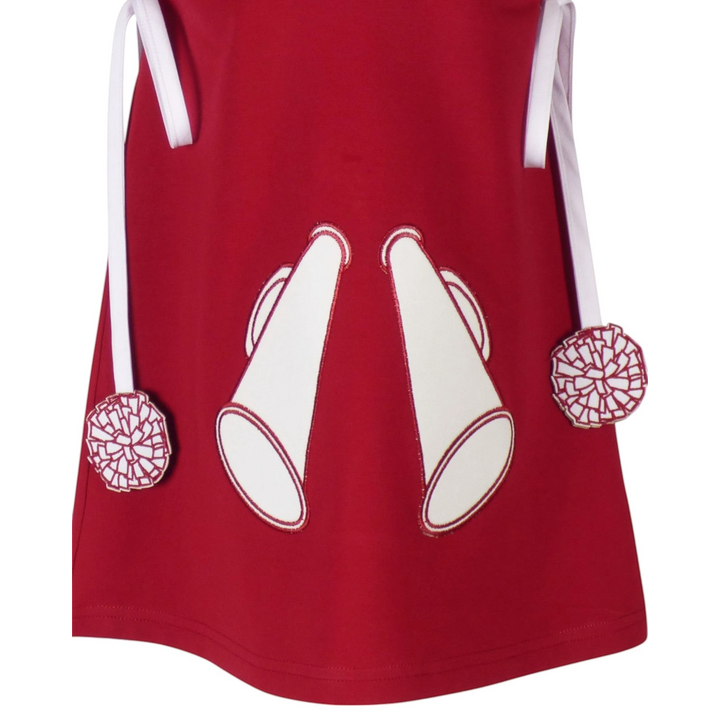 That Store burgundy cotton jumper dress featuring white megaphone appliques and pom-pom trimmed ties