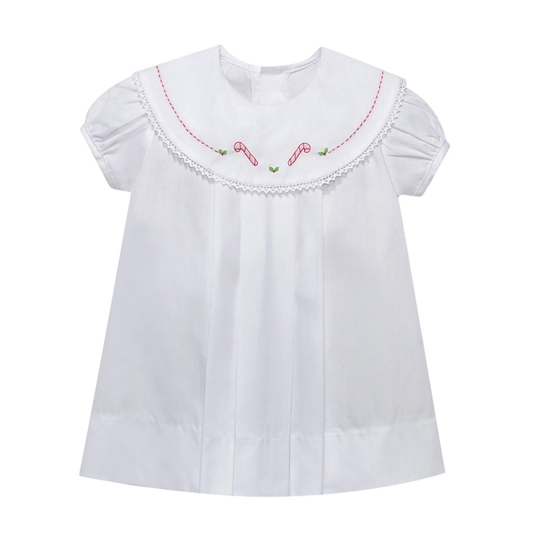 That Store white holiday dress with red candy cane embroidery, lace-trimmed round collar, and puff sleeves.