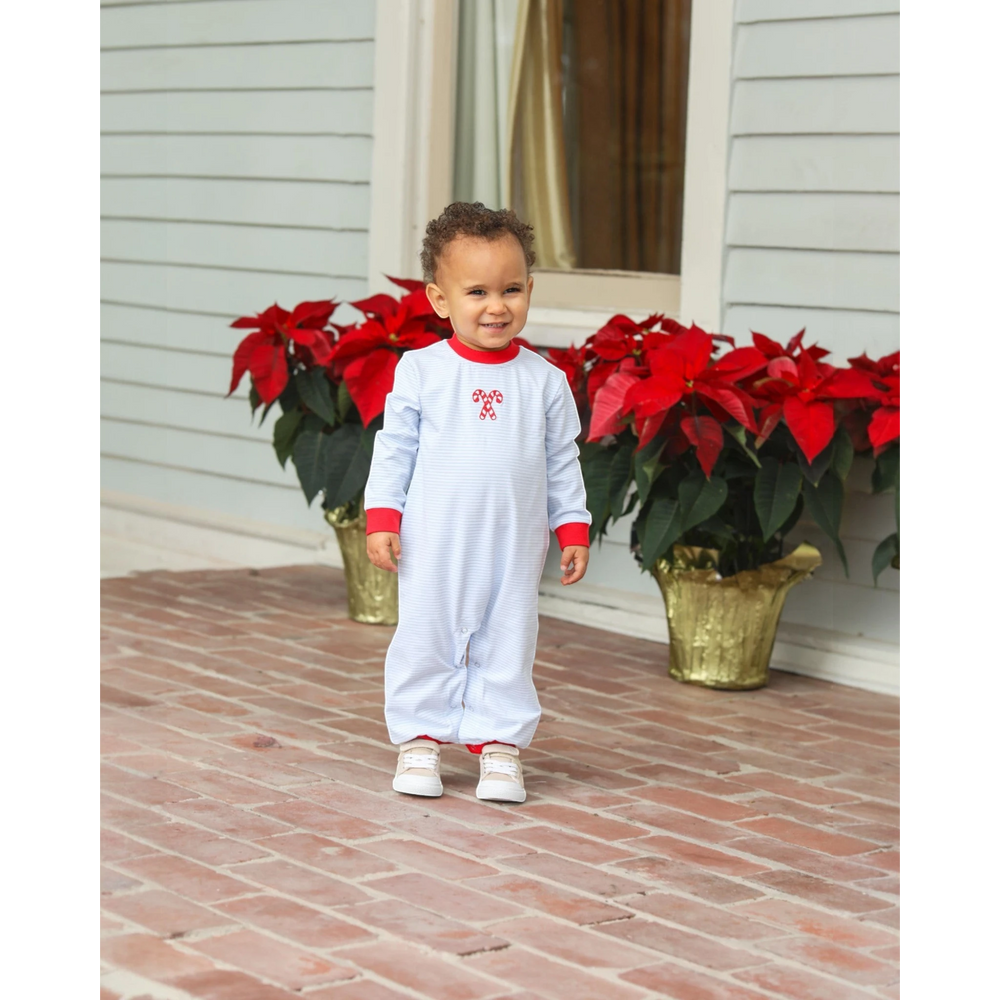 Toddler boy wearing a That Store blue striped cotton romper with festive candy cane embroidery and red trim