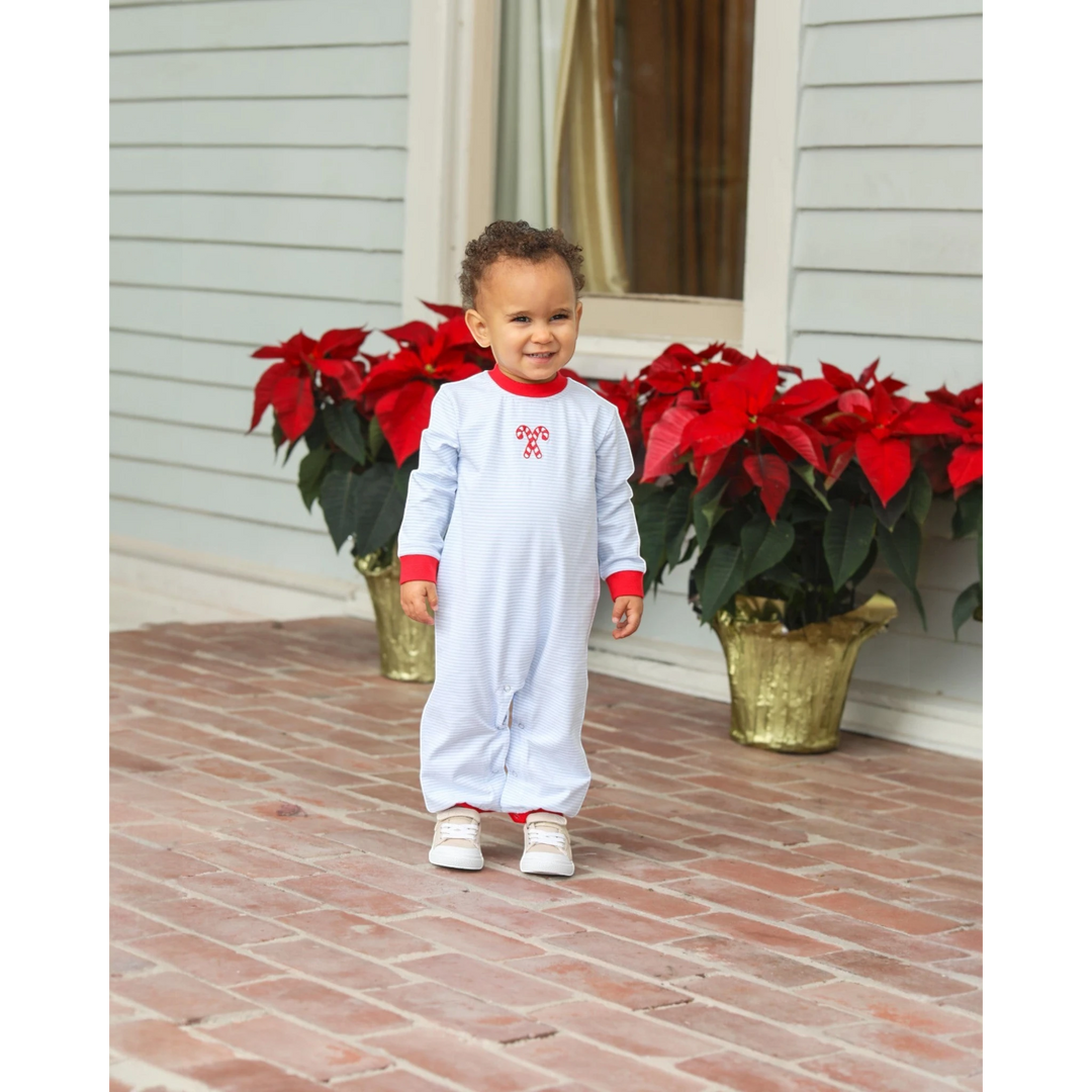 Toddler boy wearing a That Store blue striped cotton romper with festive candy cane embroidery and red trim