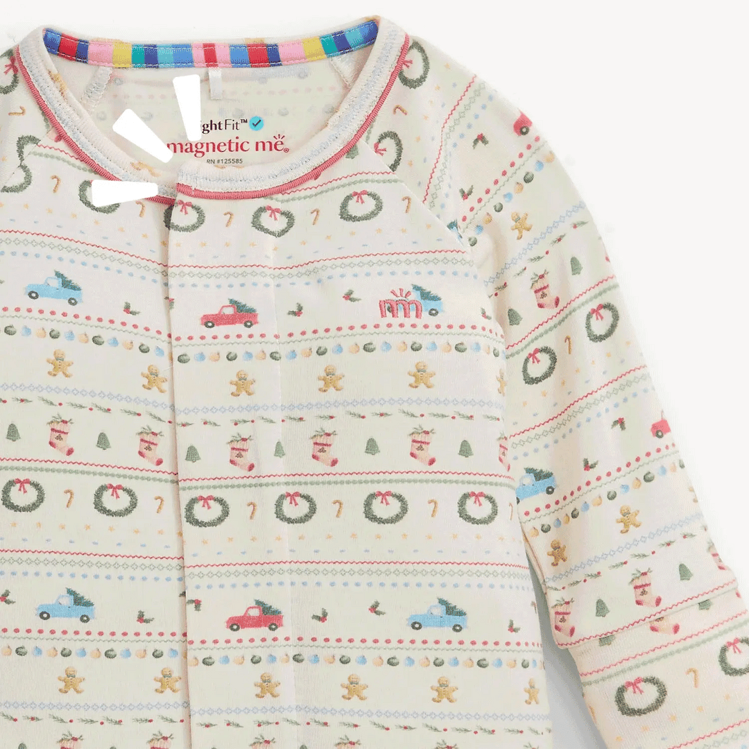 That Store RightFit magnetic baby coverall in cream with a festive Christmas pattern of cars, wreaths, and cookies.