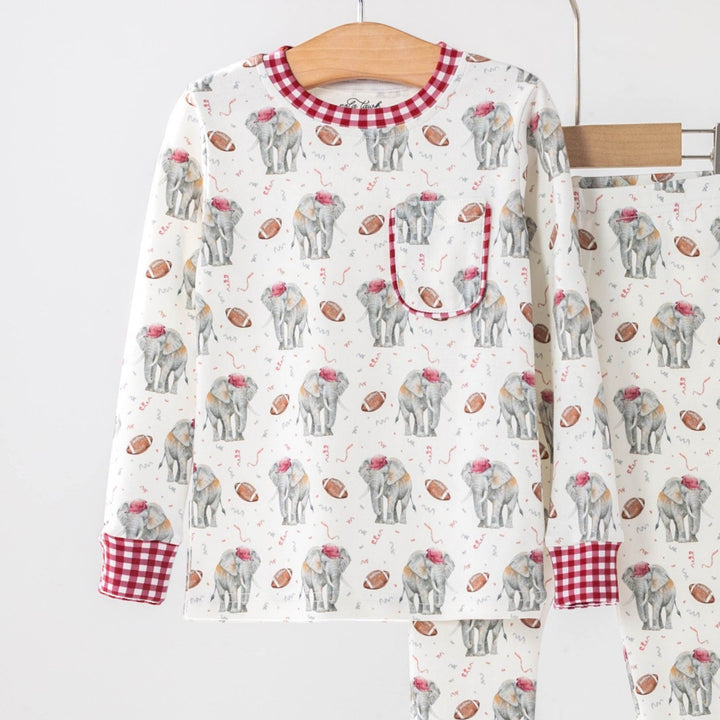 That Store organic cotton kids pajama set featuring an elephant and football print with red gingham trim details.