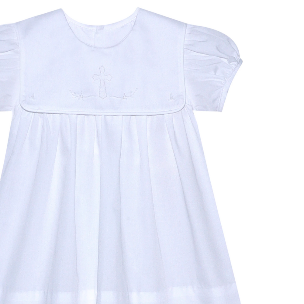 That Store Ellis Cross white dress with shadow stitched ecru cross detail, short puff sleeves, and pleated skirt.