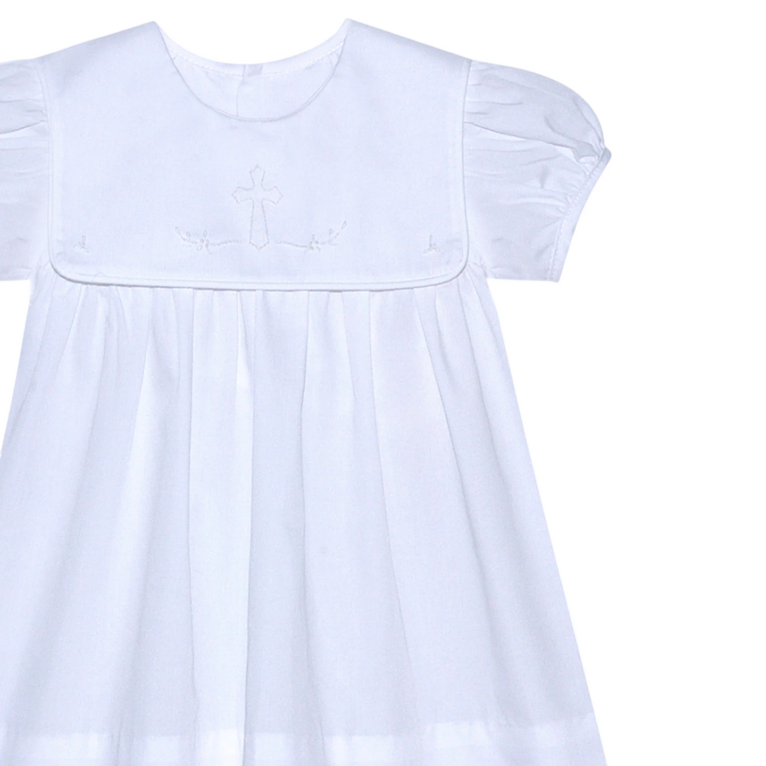 That Store Ellis Cross white dress with shadow stitched ecru cross detail, short puff sleeves, and pleated skirt.