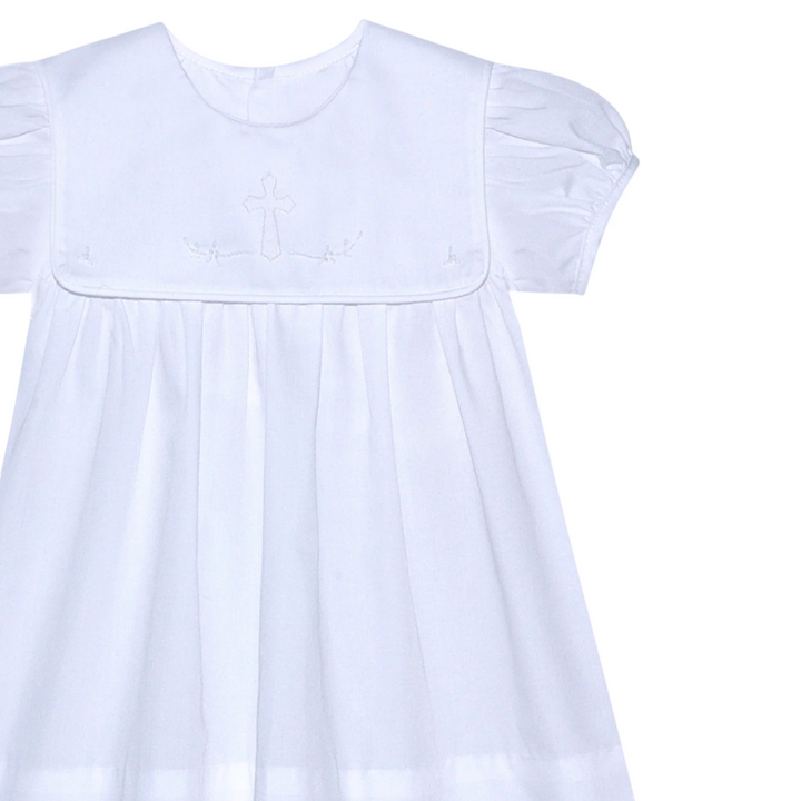 That Store Ellis Cross white dress with shadow stitched ecru cross detail, short puff sleeves, and pleated skirt.