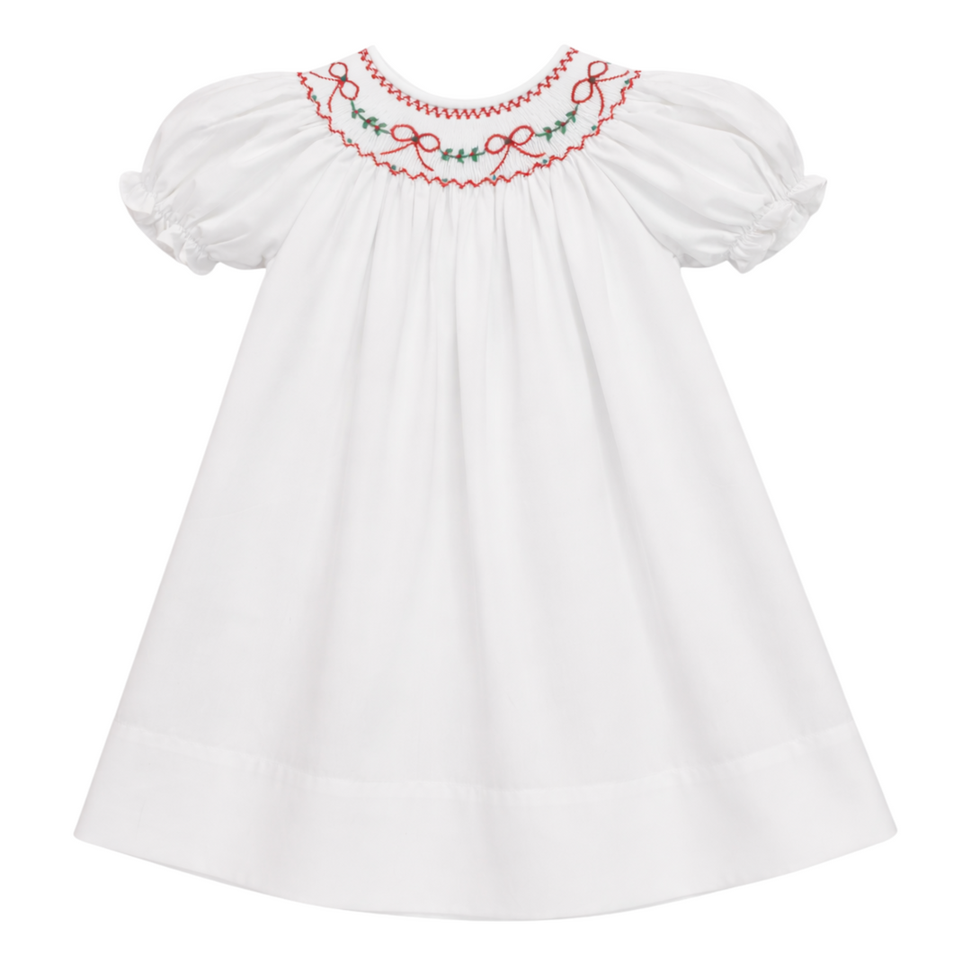 That Store white cotton girls dress featuring red bow and green holly embroidery and a scalloped collar
