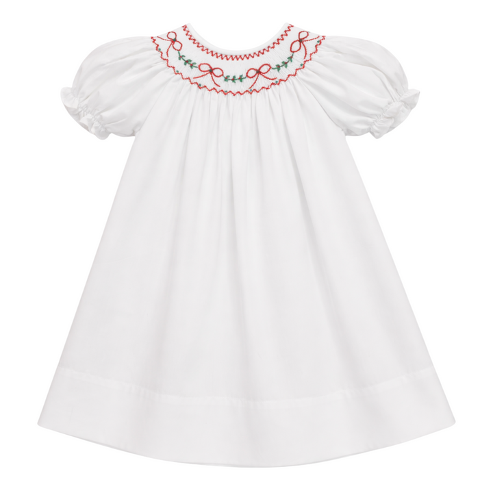 That Store white cotton girls dress featuring red bow and green holly embroidery and a scalloped collar