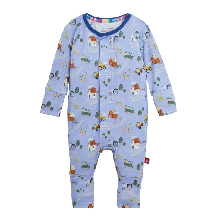That Store baby coverall in light blue modal with a farm print, featuring magnetic closures and convertible cuffs.