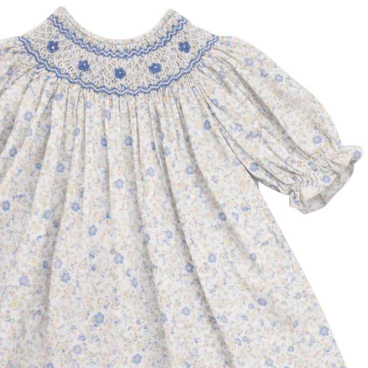 That Store girls cotton dress featuring blue and yellow bow floral print with classic blue smocking on the chest.
