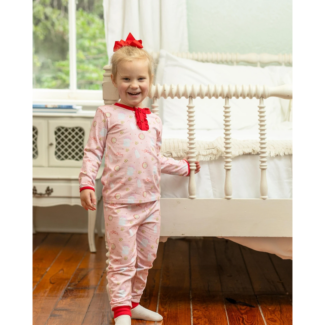 That Store Milk &amp; Cookies Ruffle Lounge Set on a smiling girl with a red bow, featuring festive holiday print.