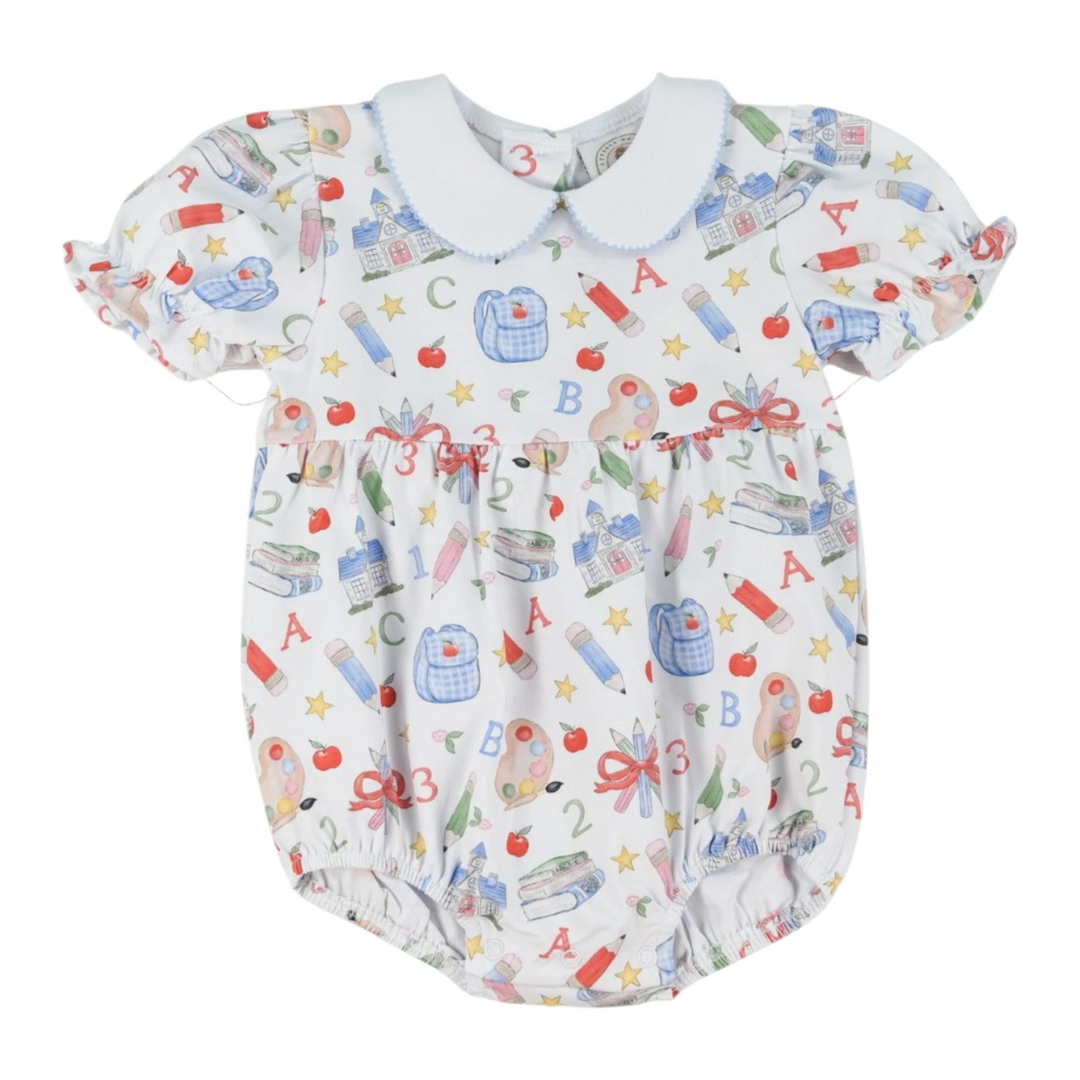 That Store girls bubble featuring a white fabric with colorful school supplies print and a blue-trimmed peter pan collar