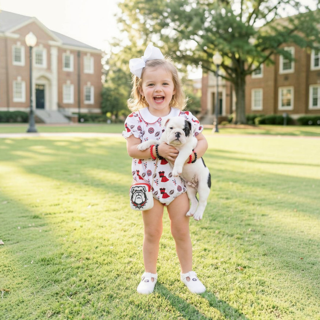 That Store girls bubble in varsity red and black with bulldog print, worn by a toddler holding a puppy on campus.