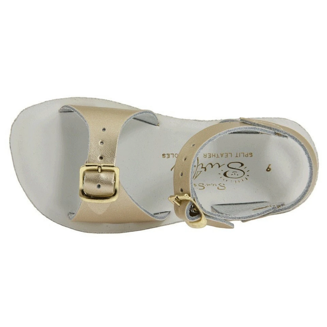 That Store gold leather surfer sandals for kids with adjustable brass buckle straps and a white footbed.