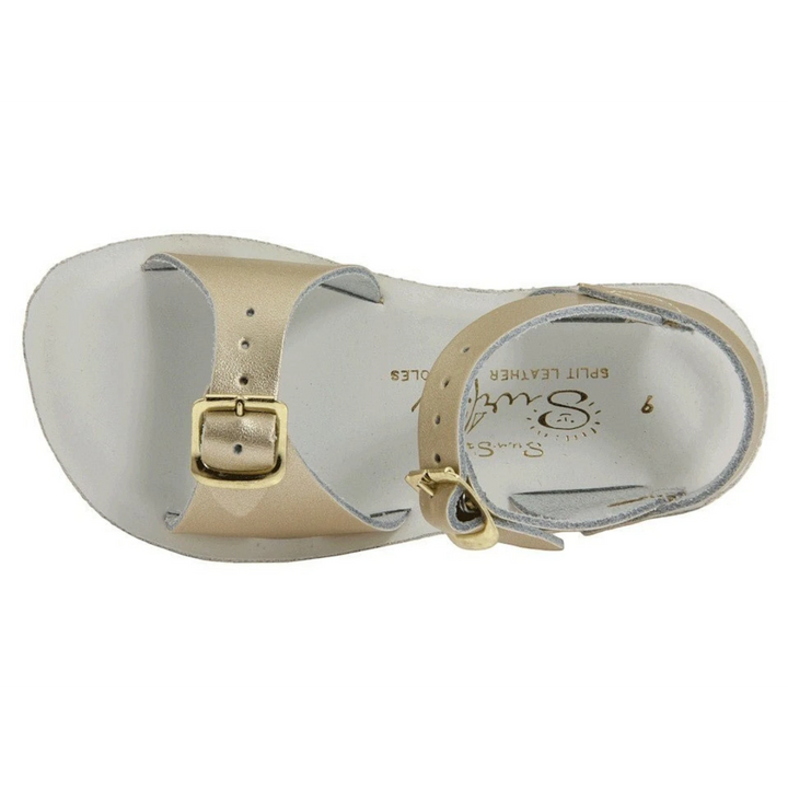 That Store gold leather surfer sandals for kids with adjustable brass buckle straps and a white footbed.