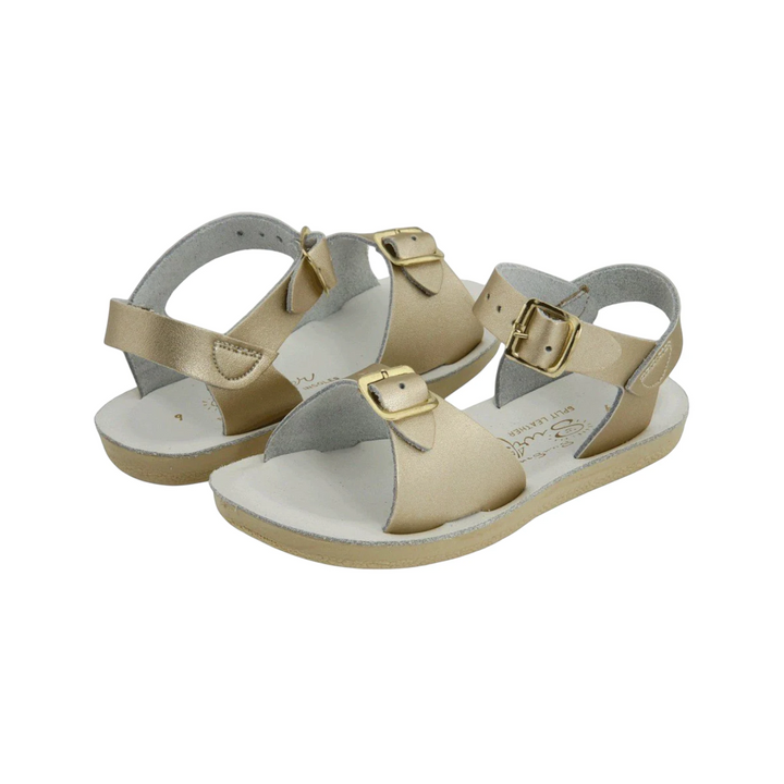 That Store Gold Surfer Sandals with water-friendly leather, brass buckles, and flexible outsoles for summer play.