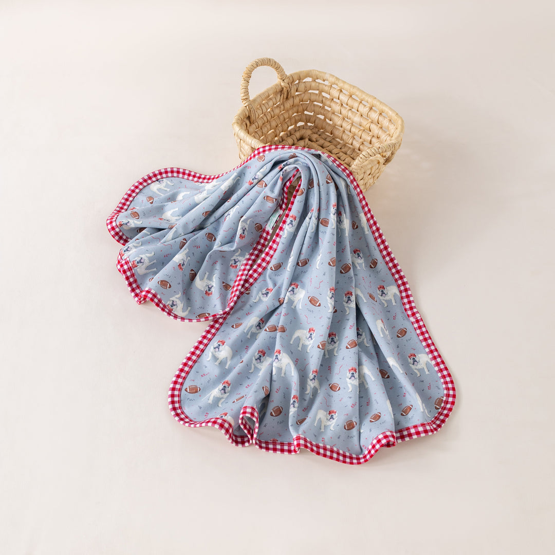 That Store organic cotton swaddle blanket in gray with football-themed bulldog print and red gingham trim