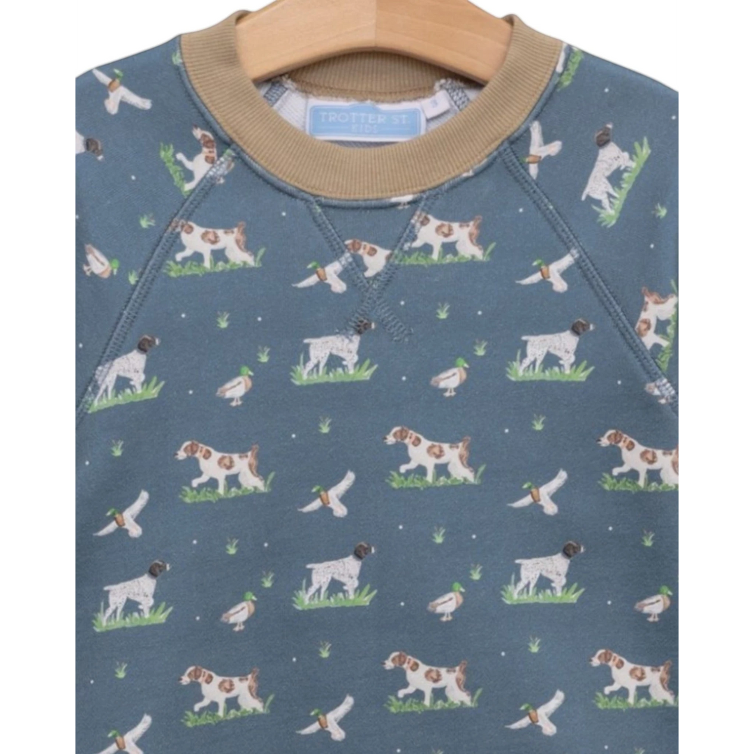 That Store boys green French terry sweatshirt with a playful hunting dog and duck print and tan ribbed collar.