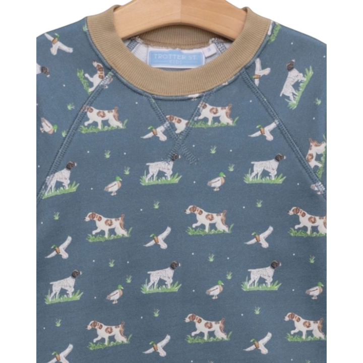 That Store boys green French terry sweatshirt with a playful hunting dog and duck print and tan ribbed collar.