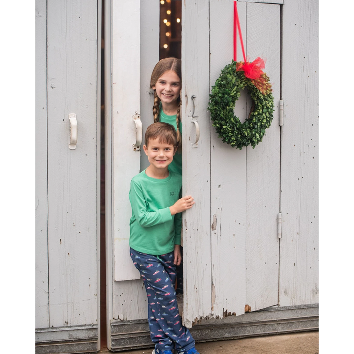 That Store green spruce long sleeve cotton t-shirt worn by a smiling boy and girl standing in a wooden doorway