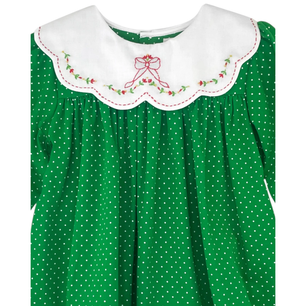That Store green polka dot dress with a white scalloped collar featuring red floral bow embroidery.