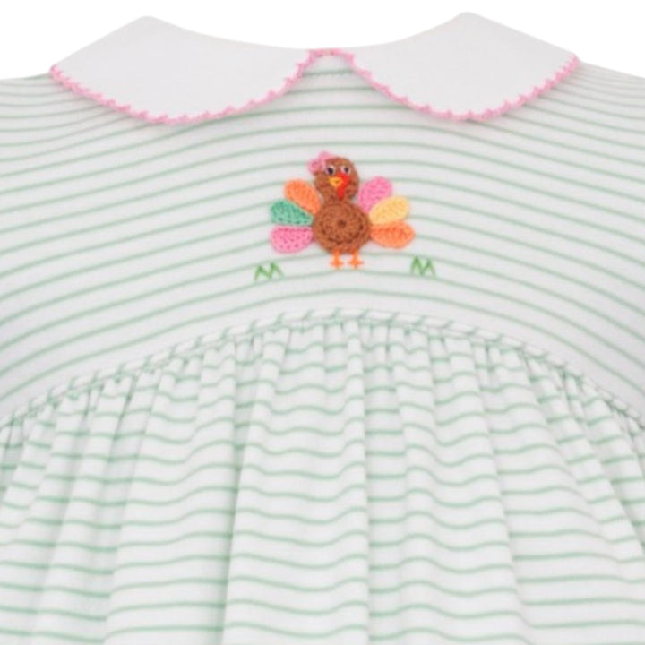 That Store girls green stripe knit dress featuring a crochet turkey appliqué and a white collar with pink trim.