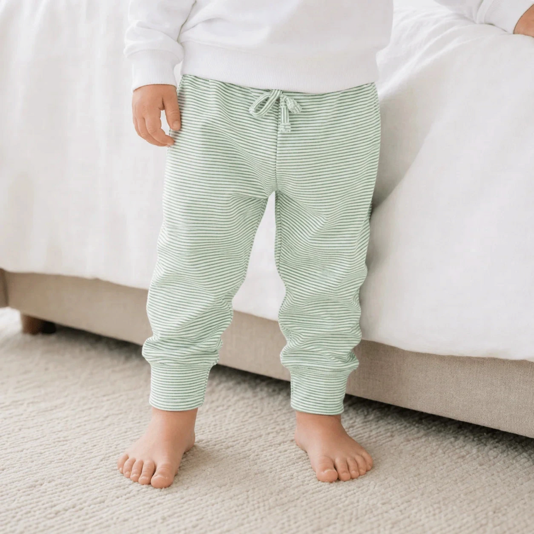 That Store baby joggers in green and white micro-stripe Pima cotton with an elastic waistband and cuffed ankles.