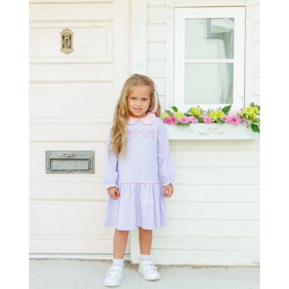 That Store lavender striped cotton dress with pink collar and bow embroidery worn by a young girl outdoors