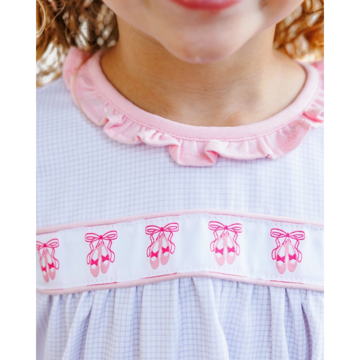 That Store lavender windowpane dress with pink ballet shoe embroidery and a ruffled collar on a young girl