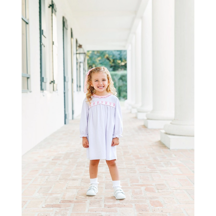 That Store lavender windowpane dress with ballet shoe embroidery worn by a smiling girl on a porch