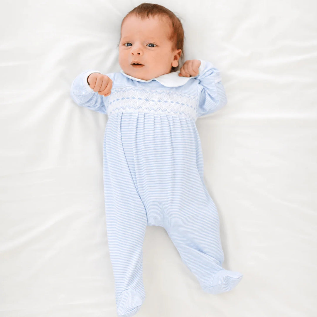 Baby wearing a That Store light blue and white striped Pima cotton footie with hand-smocking and a Peter Pan collar.