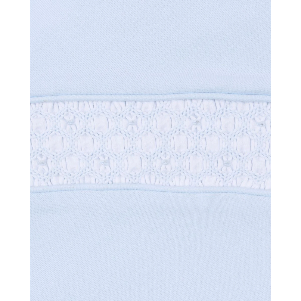Close-up of That Store light blue Pima cotton baby footie featuring intricate white hand-smocked detailing on the chest.