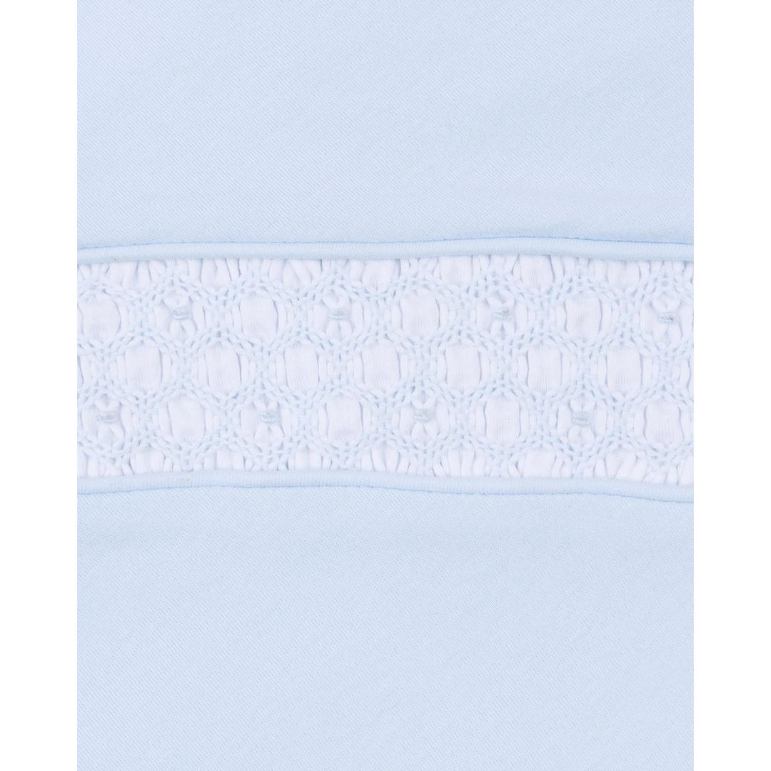 Close-up of That Store light blue Pima cotton baby footie featuring intricate white hand-smocked detailing on the chest.