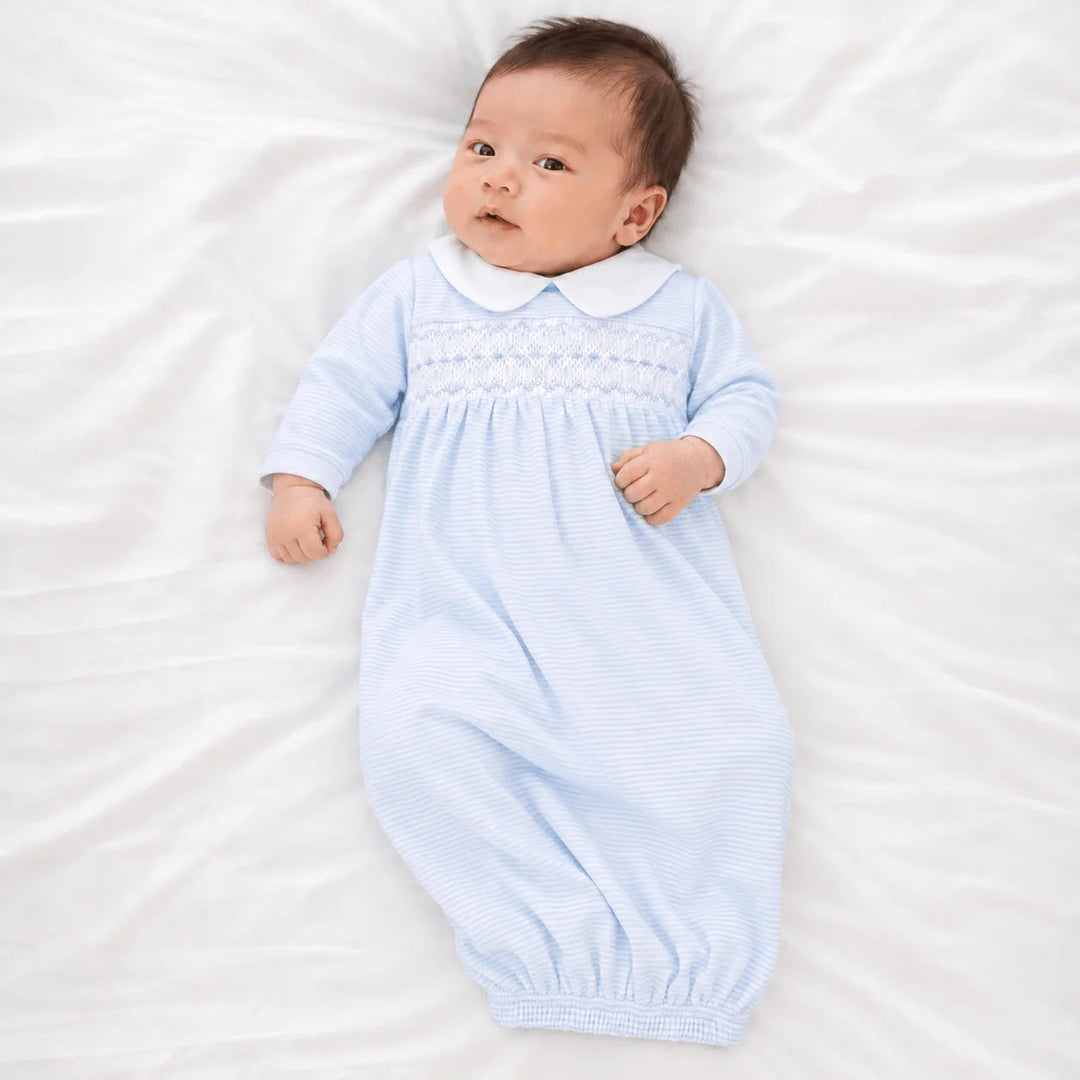Baby wearing a That Store light blue and white striped Pima cotton gown with hand-smocking and a Peter Pan collar.