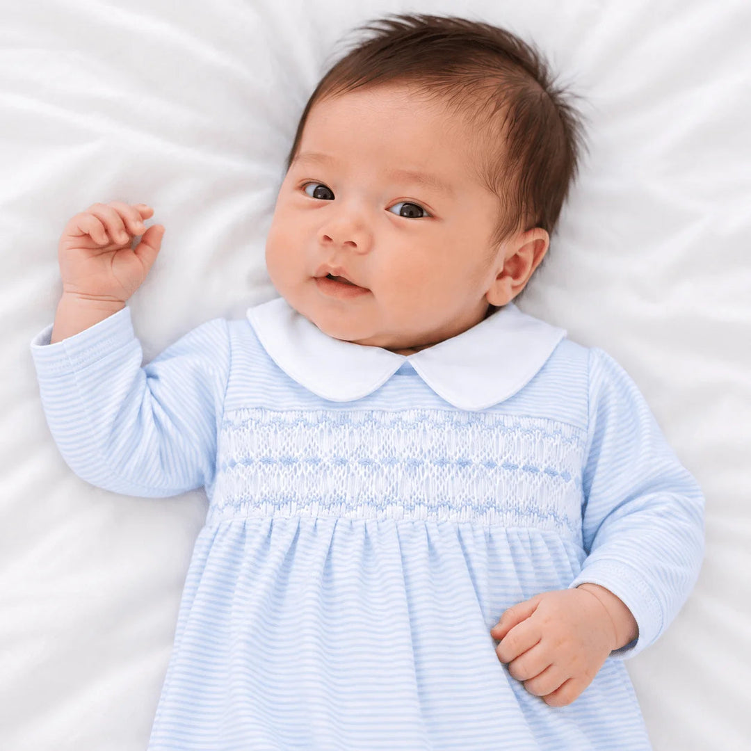 Baby wearing a That Store light blue and white striped Pima cotton gown with hand-smocked chest and Peter Pan collar.