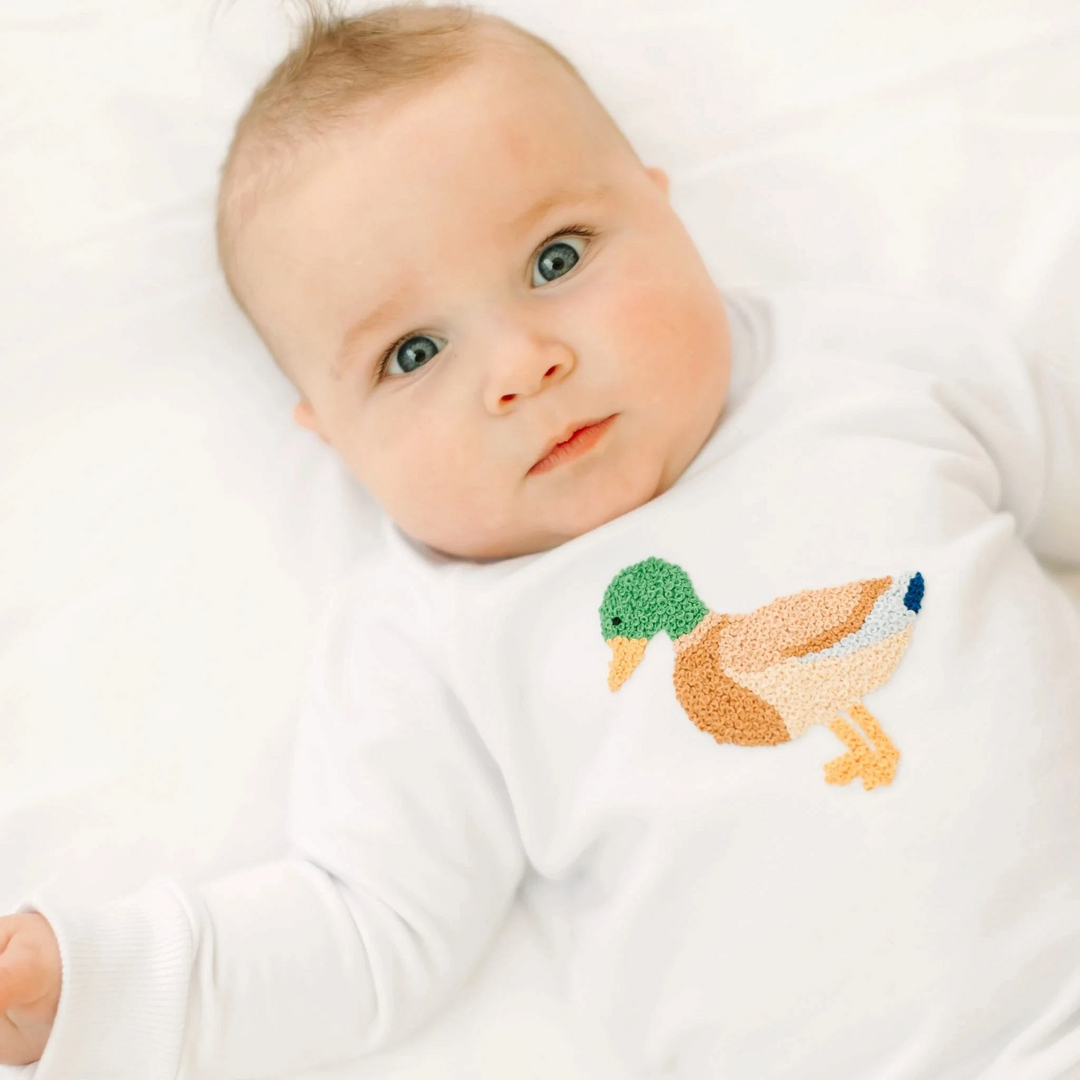 Baby wearing a white That Store Pima cotton sweatshirt with a detailed mallard duck appliqué.